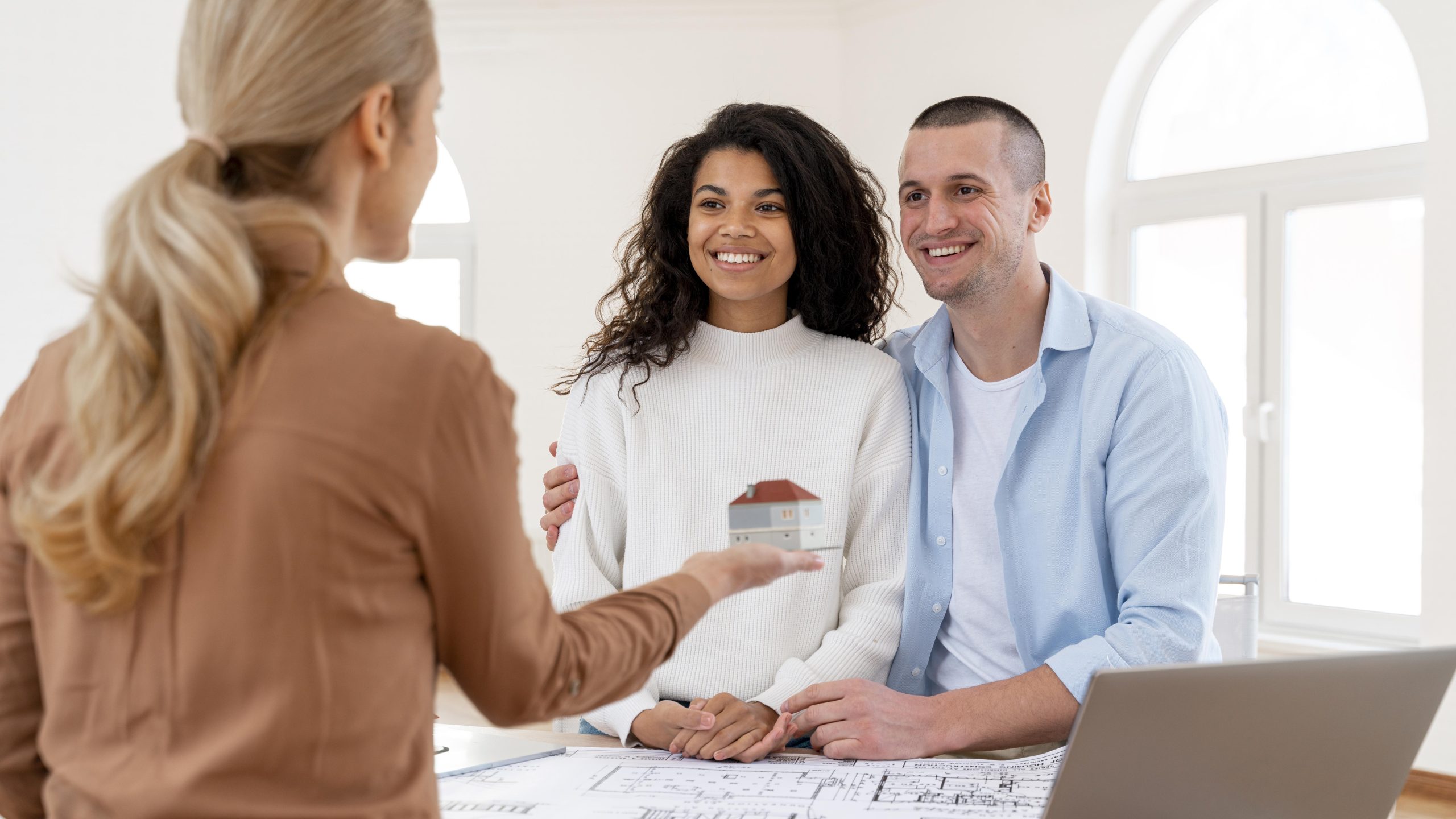 smiley-embraced-couple-conversing-with-female-realtor